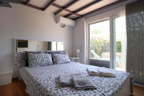 苏尼翁Thimari Sports & Spa with private pool and jacuzzi的一间卧室配有一张大床和毛巾
