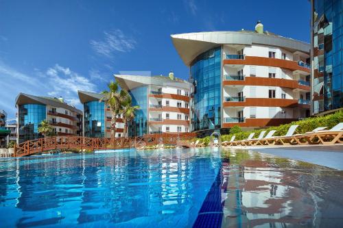 安塔利亚Onkel Rada Apart Hotel的一座大型游泳池,位于部分建筑前