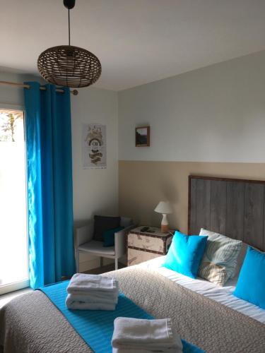 波尔尼克La Belle Verte的一间卧室配有一张带蓝色枕头的大床