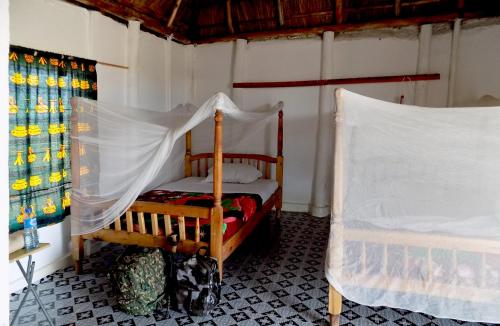 卡塞斯Kasenyi Lake Retreat & Campsite的一间卧室配有一张带蚊帐的床