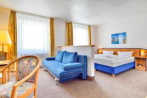 赛巴特班森班希诺霍夫沙滩酒店的一间卧室配有一张床、一张沙发和一把椅子