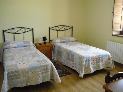 拉瓦纳尔德尔卡米诺La Candela的一间卧室设有两张床,铺有木地板