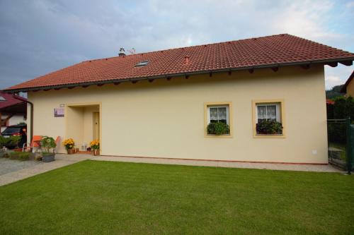 Kájov橙色阁楼公寓的前面有绿色草坪的房子
