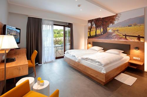 Erpeldange达姆餐厅酒店的一间卧室配有一张大床和一张书桌