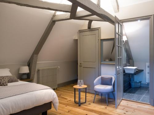 巴涅尔德比戈尔Le Relais的一间卧室配有一张床、一把椅子和一个水槽