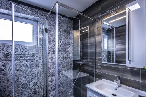萨拉热窝Apart Hotel Family的一间带玻璃淋浴和水槽的浴室