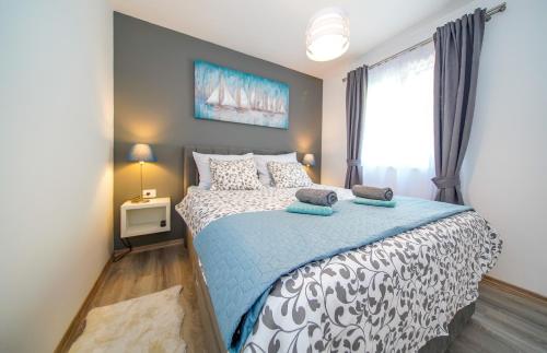 斯顿Apartmani Ponta的一间卧室配有一张带蓝色和白色床单的床。