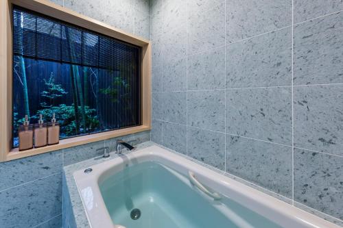 京都Kusamakura Kyoto Kawaramachi的带浴缸的浴室和窗户