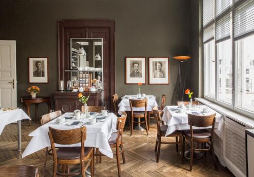 柏林选帝侯大街新艺术酒店的一间设有白色桌椅的用餐室