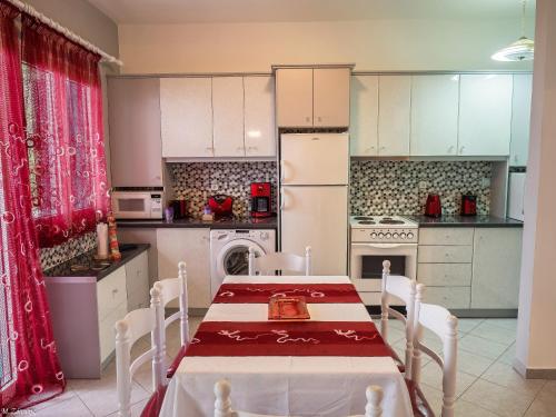 库卡里Xenia Apartment的厨房配有桌子和白色冰箱。
