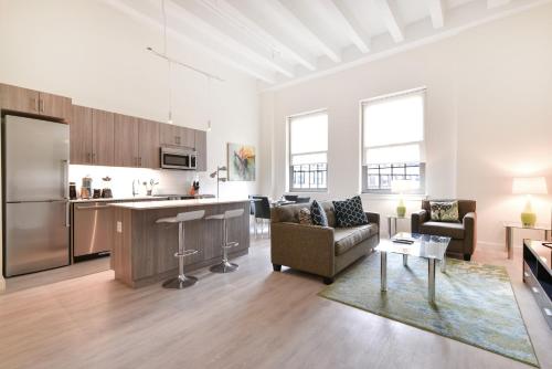 波士顿Global Luxury Suites Downtown Boston的厨房以及带沙发和桌子的客厅。