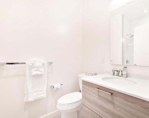 波士顿Global Luxury Suites Downtown Boston的白色的浴室设有卫生间和水槽。