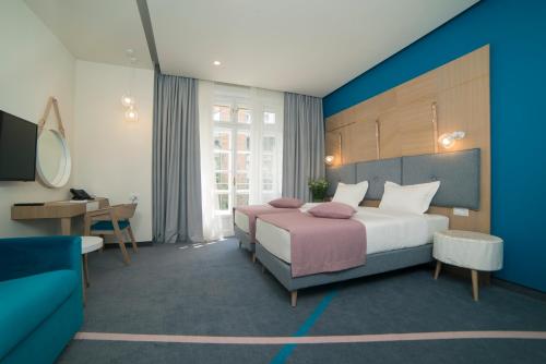 贝尔格莱德城市栖息地现代舒适套房旅馆的配有一张床和一张书桌的酒店客房