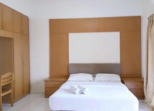 卢穆特Lumut Valley Condominium的一间卧室配有一张带两条白色毛巾的床