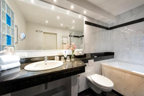 不莱梅祖尔帕斯特贝斯特韦斯特酒店的浴室配有盥洗盆、卫生间和浴缸。