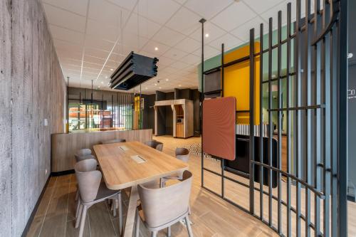 波尔多B&B HOTEL Bordeaux Centre Gare Saint-Jean的一间带木桌和椅子的用餐室