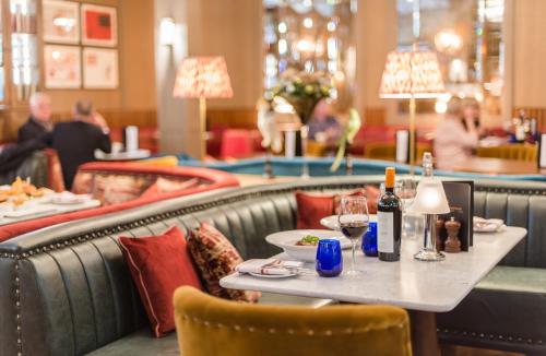 曼彻斯特景街联排别墅酒店的餐厅配有桌椅和葡萄酒瓶
