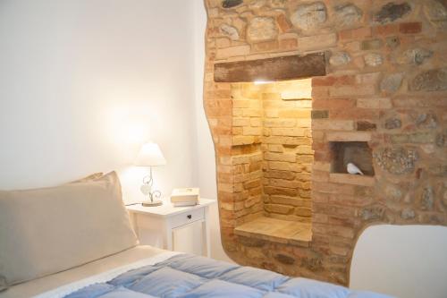 Notaresco卡萨莱阿尔隆蒂尼住宿加早餐旅馆的卧室配有石墙,毗邻一张床