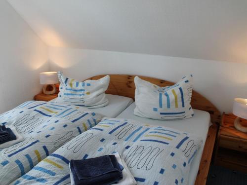 青斯特Cozy Apartment in Zingst Germany with Garden的两张带蓝色和白色枕头的床