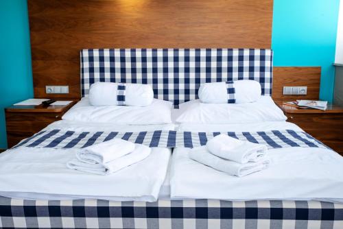 布尔诺内姆阿尔什时尚餐饮酒店的床上铺有白色毛巾的床