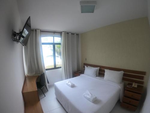 马卡埃贝拉特里克斯酒店的卧室配有白色的床和窗户。