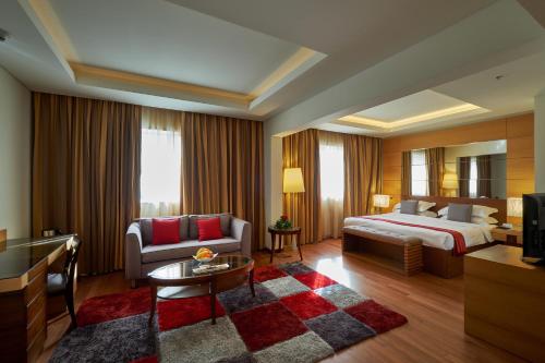 贝鲁特珊瑚海滩酒店和贝鲁特度假村的酒店客房,配有床和沙发