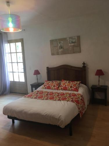 吕斯特勒Auberge de Rustréou的一间卧室配有一张床、两盏灯和一个窗户。
