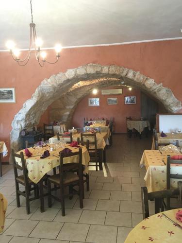 吕斯特勒Auberge de Rustréou的一间设有桌子和石拱门的用餐室