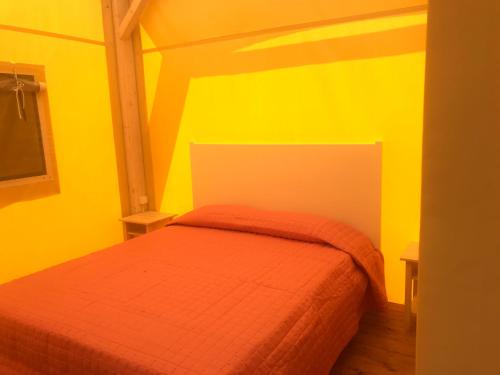 里奥托尔托Vento etrusco的一间卧室设有一张黄色墙壁的床