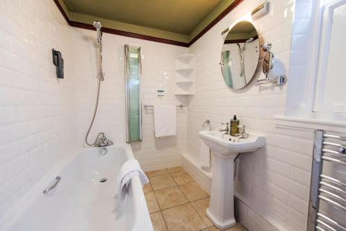 珀斯萨鲁塔什酒店的白色的浴室设有浴缸和水槽。