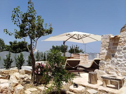 马丁纳弗兰卡Dimore Miravalle的一个带桌子和遮阳伞的庭院