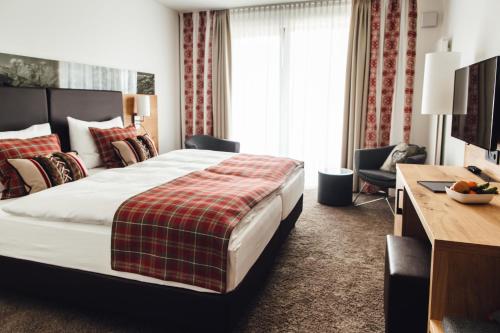 沙伊代格Hotel Edita的酒店客房设有一张大床和一张书桌。