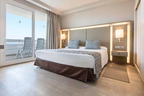美洲海滩尔卡诺春天酒店的一间卧室设有一张大床,享有海景