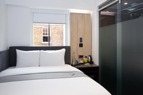 伦敦The Z Hotel Tottenham Court Road的卧室配有白色的床和窗户。