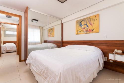 纳塔尔纳塔尔水族馆酒店的卧室配有一张白色大床和镜子