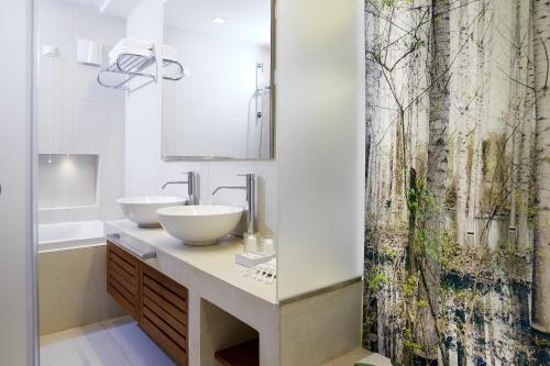 萨索斯马克亚姆斯酒店的浴室设有2个水槽和1个淋浴帘