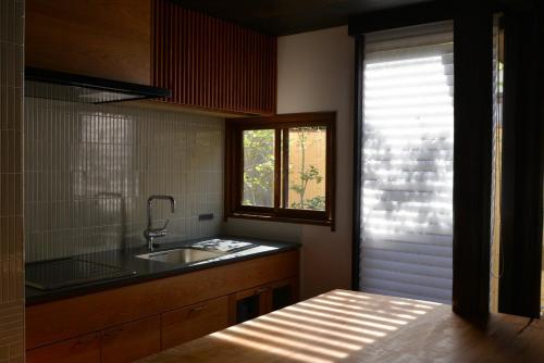 仓敷滔々 御崎 町家の宿 toutou Onzaki Machiya no Yado的厨房设有水槽和窗户。