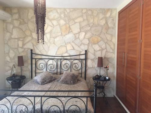 Albalate de ZoritaCasa Rural Lago Bolarque的一间卧室设有一张床和石墙