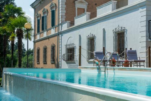 蒙泰马尔恰诺Tenuta Villa Colle Sereno的一座带两把椅子的游泳池位于大楼旁