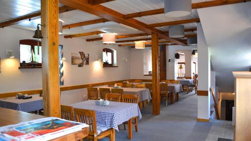 伊拉华Tawerna Kaper的一间带桌椅和木梁的用餐室