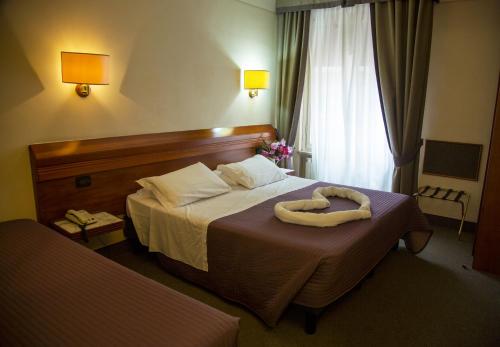 佛罗伦萨阿卡迪亚酒店的一间酒店客房,配有一张带毛巾的床