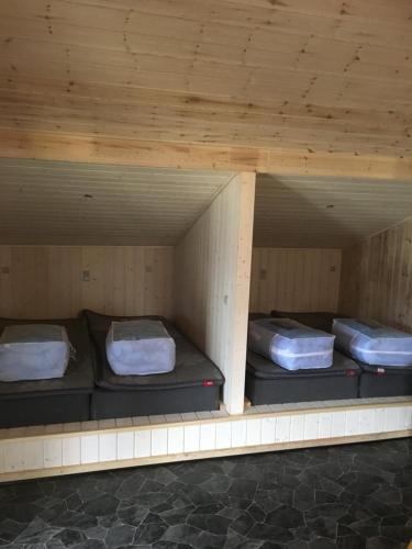 瓦伊厄斯斯特兰德维杰斯家庭小屋营地的带木天花板的客房设有三张双层床。