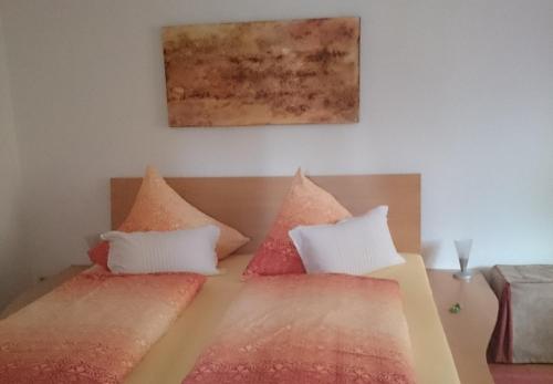 瓦瑟堡Haus Schnitzler的一间卧室配有两张带红白色枕头的床