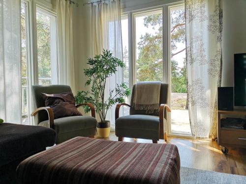罗威萨Mäntykallio的客厅配有两把椅子和大窗户