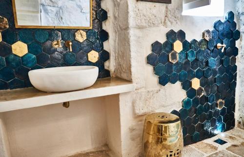 奥斯图尼White Dream的浴室设有水槽,墙上铺有蓝色瓷砖。
