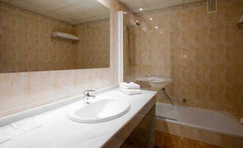 塞维利亚维尔缇切比伯兰布拉公寓的浴室配有水槽、淋浴和浴缸。