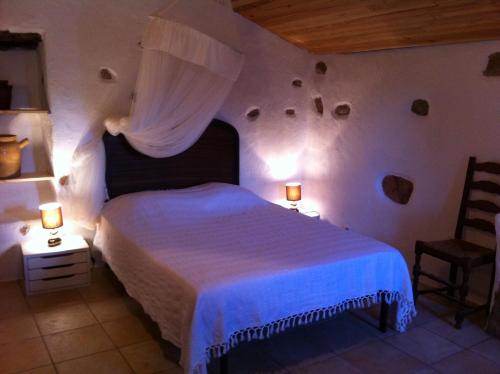 菲加里Caseddu di Chjarastella的一间卧室配有一张床、两盏灯和一把椅子