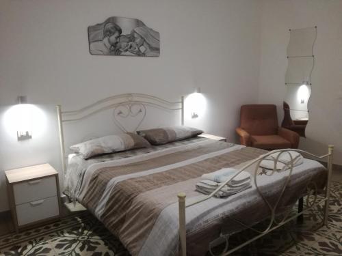 马丁纳弗兰卡Casa Retrò的一间卧室配有一张大床和一把椅子