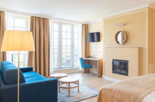 维也纳司碧思酒店的酒店客房设有蓝色的沙发和壁炉。