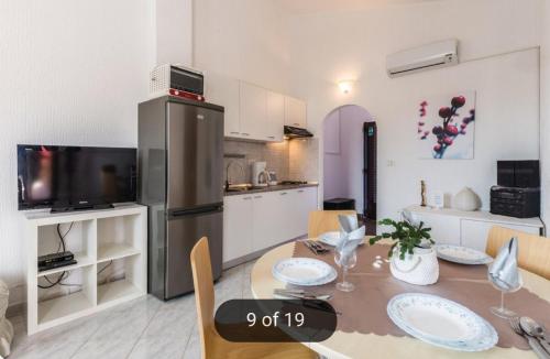 乌马格Apartmans Nadin的厨房以及带桌子和冰箱的用餐室
